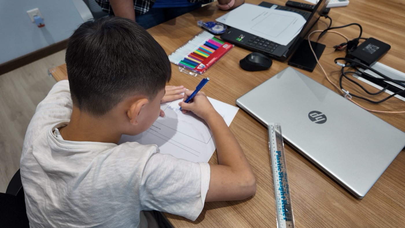 A student building the Jumping Dinosaur game at their desk